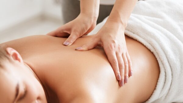 Body care. Young girl having massage, relaxing in spa salon